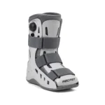 Gray Aircast medical walking boot with rigid supports, padded lining, adjustable hook-and-loop straps, and a rocker sole, shown on white; clinical and utilitarian.